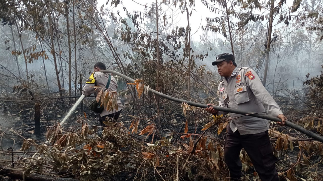 Polsek Tambang  Ikuti Giat Pendinginan Bekas Kebakaran Lahan di Wilkumnya.